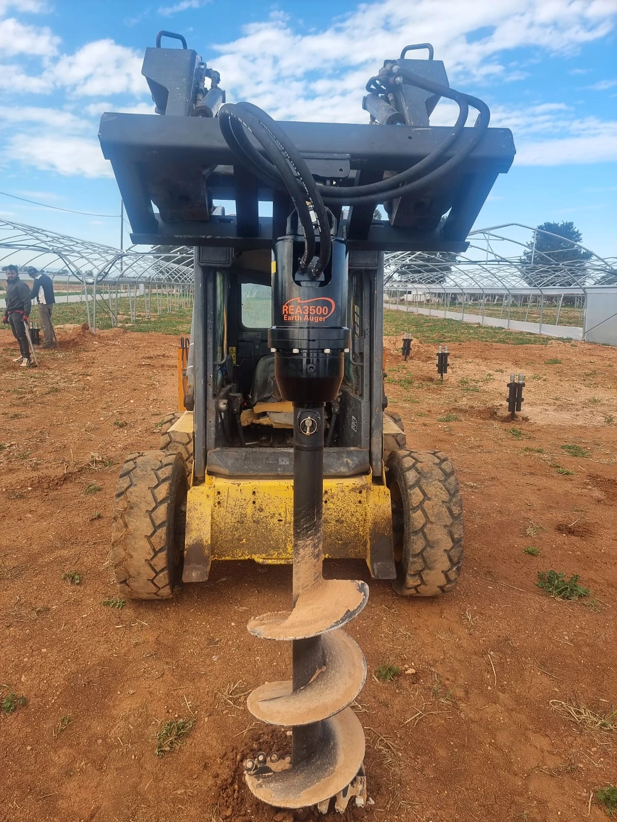 Earth auger fitted to a skid steer loader
